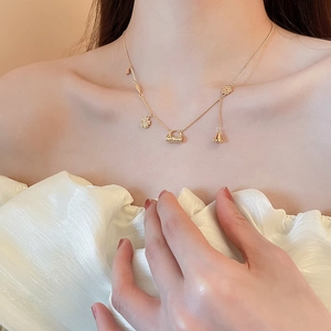 Close-up of 18k gold plated flower locket necklace with tassel on a female model