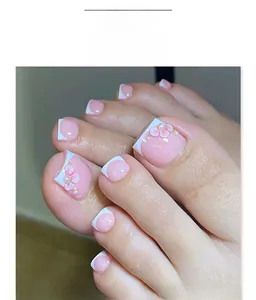 Detail of pink French press-on toenails with 3D floral accents and gold pearls