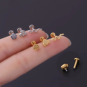 Macro view of gold and silver stud jewelry with flower, bee, and snake shapes