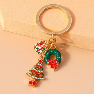 Detail of gold metal keychain with festive Christmas tree, gift box and wreath charms