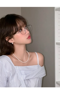 Close-up of elegant pearl necklace and star-shaped stud earrings on a female model