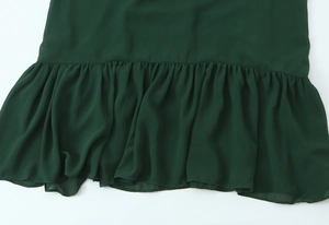 Detailed view of the dark green chiffon maxi dress with ruffled hem and flowing fabric