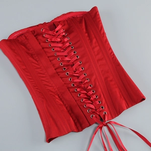 Détail d'un corset en satin rouge avec laçage réglable et œillets métalliques