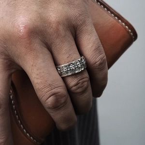 Close-up of vintage S925 silver ring featuring gothic skull and cross relief carvings