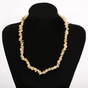 Macro shot of yellow natural crystal stone necklace beads on black velvet jewelry display
