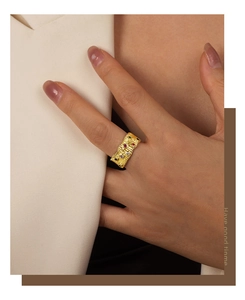 Dettaglio ravvicinato di un anello vintage in ottone dorato con zirconi colorati su una modella
