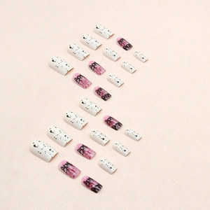 Detail of graffiti-style coffin nails with black ink splatter and letter art designs