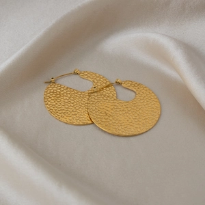 Detail shot of 18K gold plated hoop earrings with hammered texture on silk background