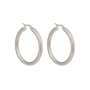 Close-up of oversized silver hoop earrings in polished minimalist stainless steel style