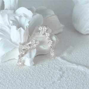 Macro view of 925 sterling silver flower drop earrings with white zircon tassels