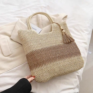 Fashionable two-tone woven straw tote bag with tassels and shoulder strap for summer beach