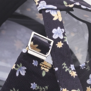 Détail de la casquette en velours côtelé fleuri avec boucle de réglage en métal