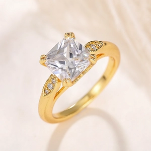 Detail eines quadratischen Zirkonia-Goldrings mit seitlichen Blattakzenten und Mikro-Pavé