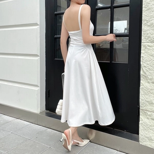 Detail view showing the elegant ruched waist and flowing A-line hem of the white maxi dress