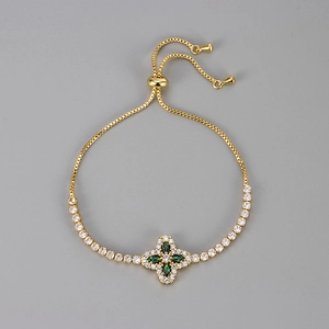 Detail of adjustable gold bracelet with green zircon clover pendant and slider clasp
