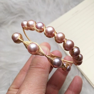 Detail of 14K gold-wrapped wire bracelet featuring multiple pink freshwater pearls