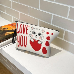 Portable cat and heart print makeup bag with zipper and handle on a wooden desk
