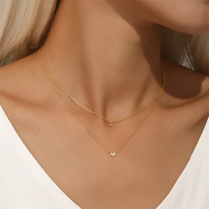 Detail of double-layered gold necklace with star and heart zircon pendants on model