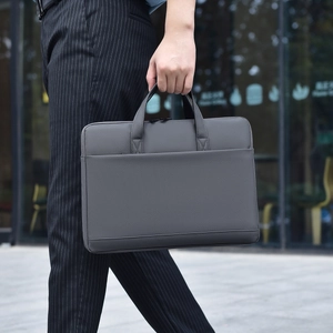 Business man carrying slim waterproof dark grey laptop briefcase for 14-16 inch computers