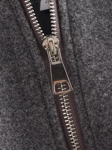Détail du blouson aviateur gris foncé montrant la texture douce et la fermeture éclair argentée