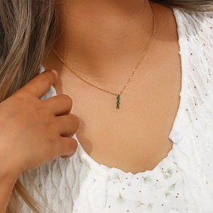 Detailed view of 18K gold plated bamboo pendant necklace with three green gemstones