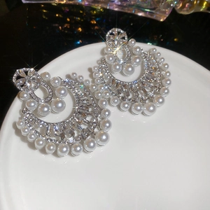 Dettaglio degli orecchini a fiore con perle e cristalli lucenti in stile retrò francese