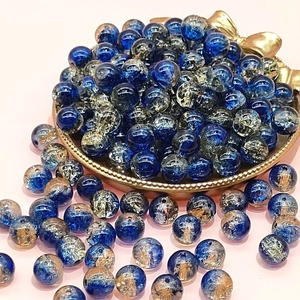 Close-up of 10mm blue and gold crackle glass beads for DIY jewelry making and crafts