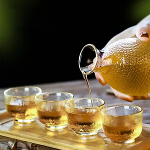 Macro detail of heat-resistant hammered glass wine set with gold rim and liquid pouring