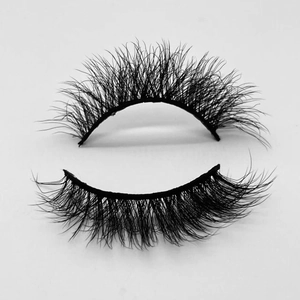 Macro shot of dense black faux mink eyelashes with dramatic curl on a grey background