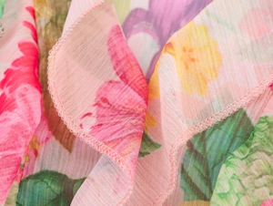 Close-up of pink floral poplin fabric showing ruffle edges and delicate texture
