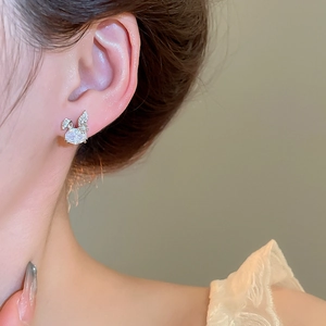 Detail of silver rabbit stud earring with cubic zirconia on a model's ear