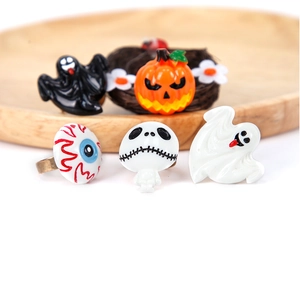 Detail of five Halloween rings including pumpkin and skull on a wooden display