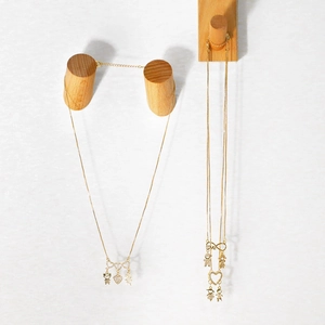 Detail of gold family necklaces with heart, boy, girl pendants and love engraving
