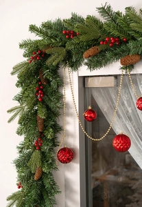L-shaped Christmas garland with PE pine needles, red berries, cones and baubles on window