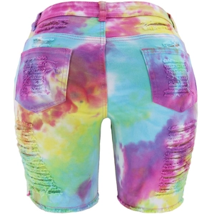 Detail of high-waist tie-dye denim shorts showing back pockets and distressed frayed edges