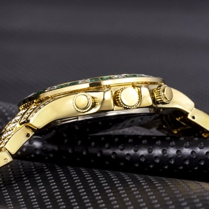 Macro side view of gold-plated crystal-encrusted watch case and polished push buttons
