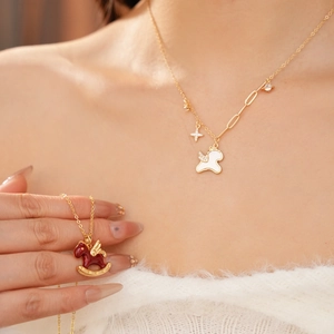 Detailed view of horse necklaces featuring white unicorn and red enamel winged pony designs