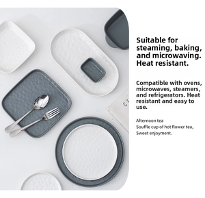 Close-up of minimalist textured ceramic plates with hand-hammered finish in white and grey