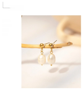 Detail of vintage 18k gold plated stainless steel earrings with white freshwater pearls