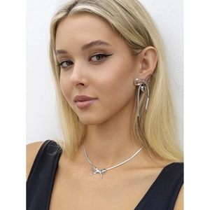 Silver bow jewelry set with heart pendant earrings and snake chain necklace on model