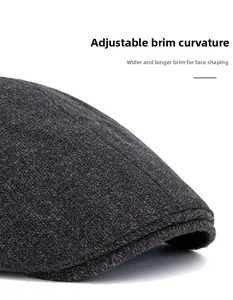Detail of grey wool newsboy cap showing reinforced stitching and curved foldable brim