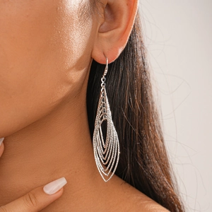Silver multi-layer leaf drop earrings with matte texture shown on model's ear