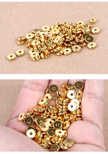 Close-up of golden flat circular brass spacers for DIY jewelry making in palm