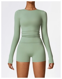 Détail d'un ensemble de yoga vert sauge avec manches longues et short taille haute