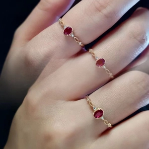 Elegant gold plated ring set with oval red rubies and diamonds in a vintage lace style