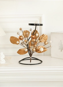 Close-up of elegant Christmas iron candle holder with gold leaves and pearl decorative beads