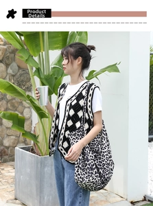 Detail of a leopard print canvas tote bag with a knitted diamond pattern vest outdoors