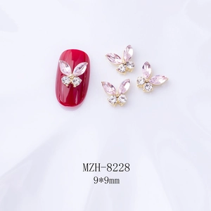 Détail de bijoux d'ongles papillon 3D avec cristaux roses et base dorée de 9x9mm