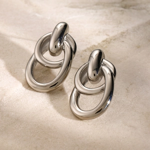 Close-up of interlocking silver double ring earrings in polished stainless steel