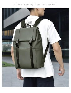 Close-up of olive green backpack with dual buckle closures worn by a model in urban setting